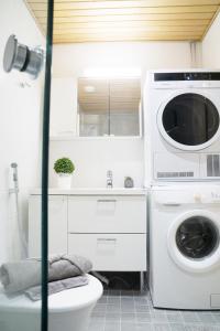 uma casa de banho com uma máquina de lavar roupa e um WC em City center 1R studio with perfect view, parking em Oulu