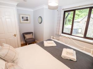 - une chambre avec un lit, une fenêtre et une chaise dans l'établissement Babbling Brook, à Ambleside
