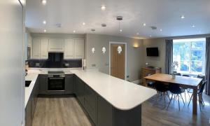 a kitchen with a large white counter top and a table at Gale Mews in Ambleside