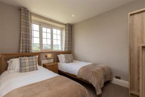 a bedroom with two beds and a window at Gale Mews in Ambleside