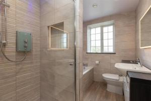 a bathroom with a shower and a toilet and a sink at Gale Mews in Ambleside +7 photos