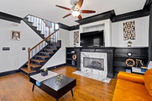 a living room with a fireplace and a ceiling fan at Vine City Bee Hive in Atlanta