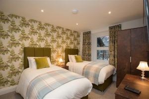 ein Hotelzimmer mit 2 Betten und einem Fenster in der Unterkunft Heatherley in Ambleside