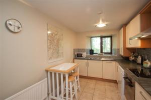 a kitchen with a table and a counter top at Over Ghyll in Ambleside +6 photos
