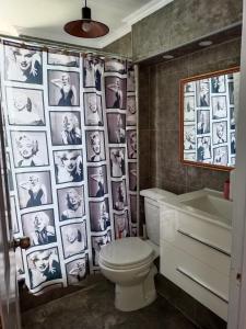 a bathroom with a toilet and a wall of photos at Espectacular Departamento frente al mar in Antofagasta