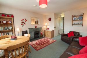 a living room with a table and a fireplace at Honeypot Cottage in Ambleside