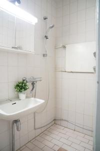 a white bathroom with a sink and a mirror at 4-room apartment. Oulu city center in Oulu