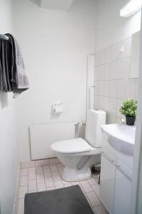 a white bathroom with a toilet and a sink at 4-room apartment. Oulu city center in Oulu