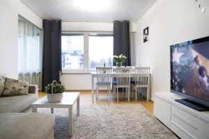 a living room with a couch and a tv and a table at 4-room apartment. Oulu city center in Oulu