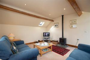 a living room with a blue couch and a table at Cygnet Cottage in Keswick