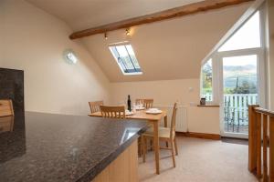een keuken en eetkamer met een tafel en een raam bij Cygnet Cottage in Keswick