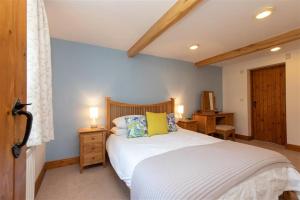 a bedroom with a white bed with two lamps on it at Cygnet Cottage in Keswick