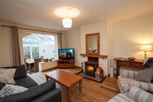 Una sala de estar con un sofá y una chimenea. en Little Brook, en Ambleside