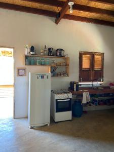 eine Küche mit Kühlschrank und Herd in der Unterkunft Chalé na Praia de Macapá Piaui in Luis Correia