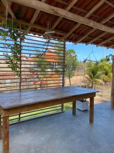 eine große Holzbank unter einem Dach in der Unterkunft Chalé na Praia de Macapá Piaui in Luis Correia