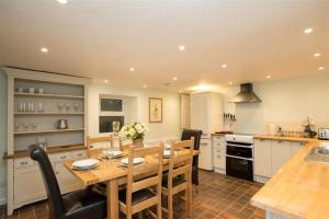 a kitchen with a wooden table and a dining room at Chapel Hill Cottage in Ambleside