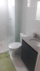 a bathroom with a toilet and a sink and a shower at Residencial Santos Dumont in Mongaguá +12 photos