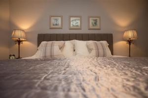 a bedroom with a large bed with two lamps at Chapel Hill Cottage in Ambleside