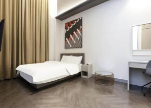 1 dormitorio con cama blanca y escritorio en H Avenue Hotel Idae Shinchon en Seúl