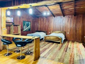 a room with two beds and a table and chairs at Cabañas La Montaña Mountain Lodge in Monteverde Costa Rica