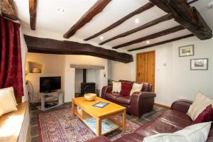- un salon avec un canapé et une table dans l'établissement Lowfold Cottage, à Ambleside