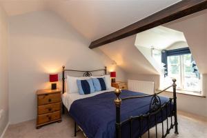 - une chambre avec un lit bleu et une fenêtre dans l'établissement Lowfold Cottage, à Ambleside