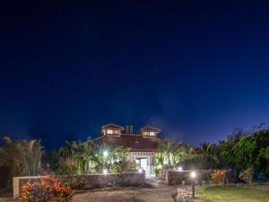 una casa grande por la noche con luces en Hotel La Teada Iriomote, en Iriomote