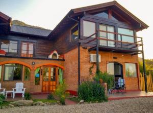 a large brick house with a porch and patio at Balcon Al Paradiso in Santa Rosa de Calamuchita