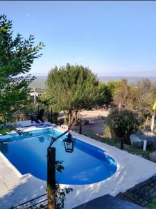 a blue swimming pool with a street light and trees at Balcon Al Paradiso in Santa Rosa de Calamuchita