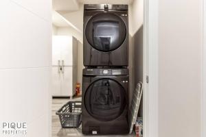 a washing machine sitting on top of a machine at NEW, Mountain Chic Suite, Whyte Avenue, Netflix, WiFi, Sleeps 6 in Edmonton