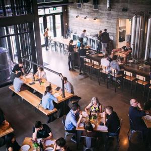 a group of people sitting at tables in a restaurant at NEW, Mountain Chic Suite, Whyte Avenue, Netflix, WiFi, Sleeps 6 in Edmonton