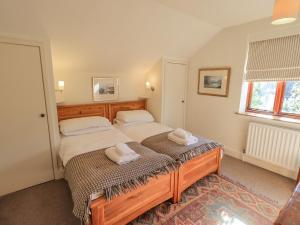 a bedroom with two beds with towels on them at Croft in Grasmere