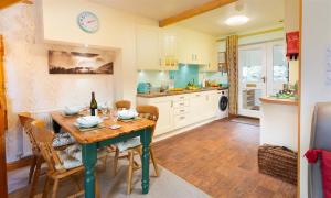 a kitchen with a wooden table and chairs and a dining room at Lingmoor View in Ambleside +7 photos