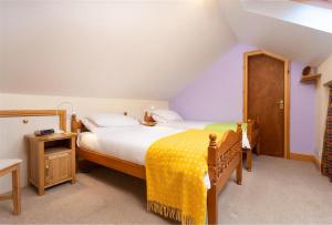um quarto com uma cama grande e um cobertor amarelo em Lingmoor View em Ambleside