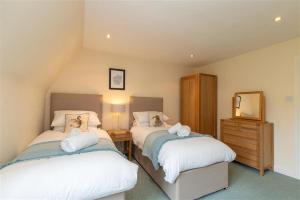 um quarto com 2 camas e uma cómoda com um espelho em Windermere Suite em Ambleside