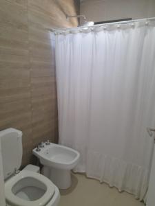 baño con aseo y cortina de ducha blanca en excelente casa con pileta en Luján de Cuyo