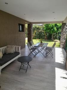 un patio con sofá, sillas y mesa en excelente casa con pileta en Luján de Cuyo