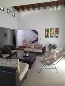 una sala de estar con sofás y sillas y una escalera en excelente casa con pileta en Luján de Cuyo