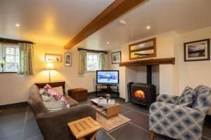a living room with a couch and a fireplace at Forest Cottage in Coniston