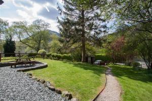 a park with a picnic table and a bench at Grisedale Cottage in Keswick