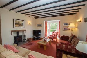 a living room with two couches and a fireplace at Grisedale Cottage in Keswick