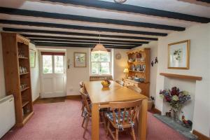 a dining room with a wooden table and chairs at Grisedale Cottage in Keswick