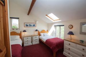 a bedroom with two beds and a window at Grisedale Cottage in Keswick