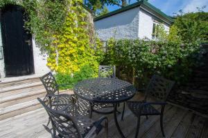 a black table and chairs on a wooden deck at Greystones in Bowness-on-Windermere +7 photos