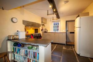 cocina con nevera y estantería con libros en Thomas Grove House, en Penrith 15 fotos más