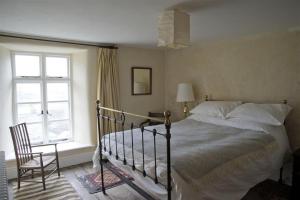 una camera con un letto e una sedia e una finestra di Thomas Grove House a Penrith