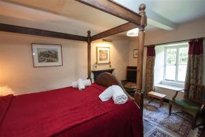 a bedroom with a red bed with towels on it at Yew Tree Farm in Coniston