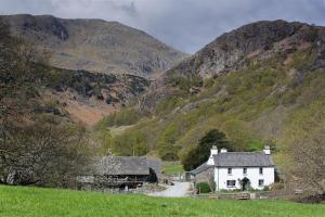 a white house in the middle of a mountain at Yew Tree Farm in Coniston
