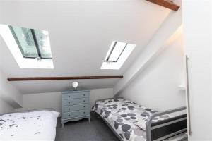 a attic bedroom with a bed and two windows at The Gallery in Grasmere