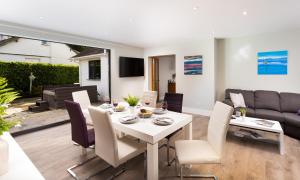 a dining room and living room with a white table and chairs at Glebe Holme in Windermere